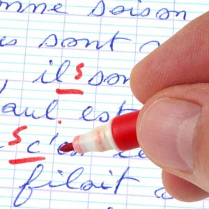 un professeur corrige la dictée d’un élève