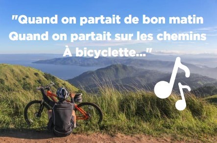 homme assis sur le sol qui admire le paysage derrière son vélo avec les paroles de la chanson de Yves Montant à bicyclette